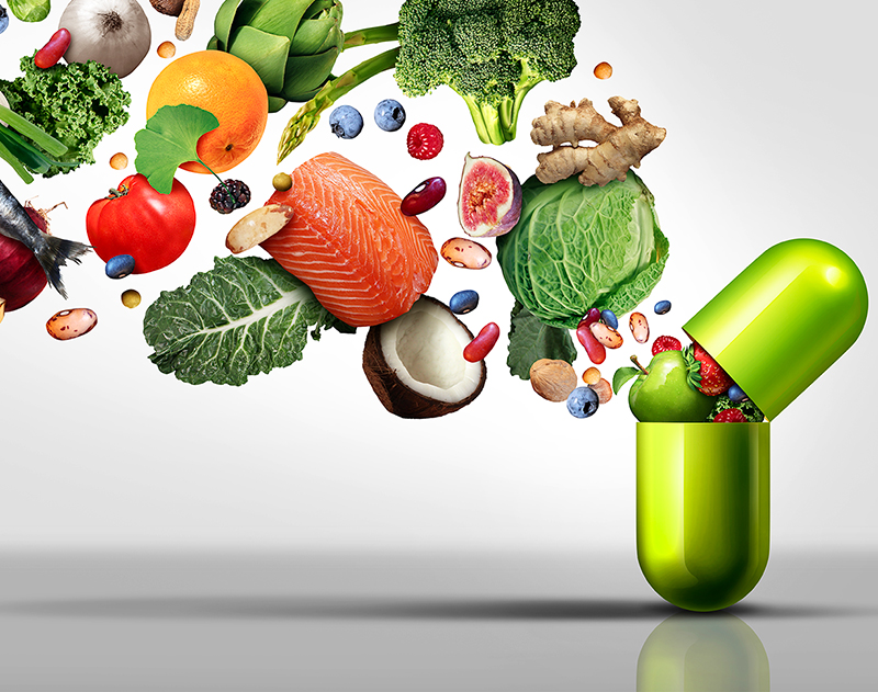 Fruits, légumes et noix s'échappant d'une gélule verte de supplément naturel