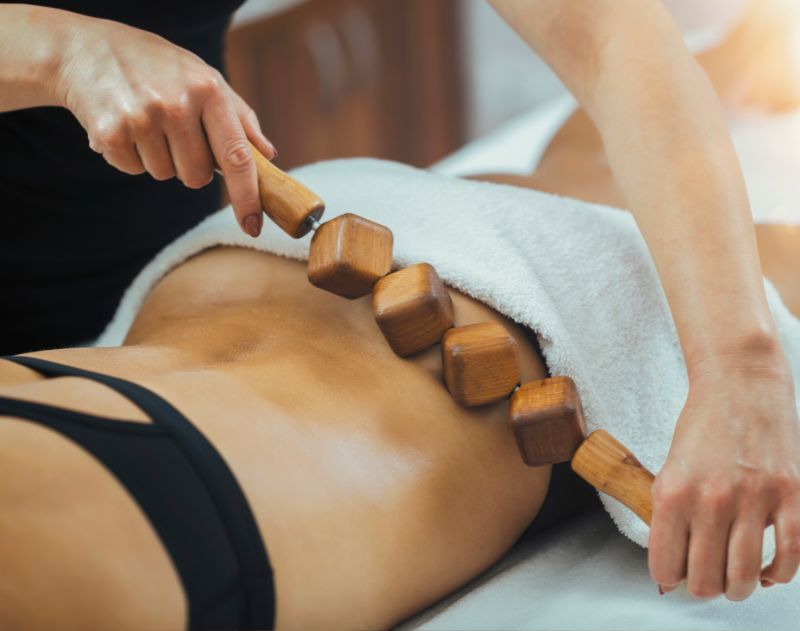 Malina Thorng, massothérapeute, utilisant un rouleau de bois sur le dos d'une cliente
