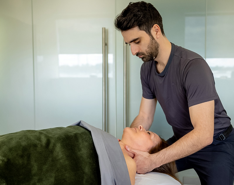 Alexander Perron, massothérapeute à Laval, effectuant un massage du cou